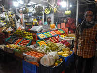 A person passes next to a fruit shop inside a wholesale market in Kolkata, India, on November 24, 2024. (