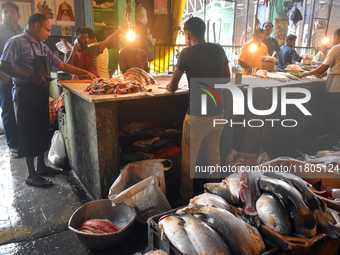 Vendors prepare fish inside a wholesale market in Kolkata, India, on November 24, 2024. (