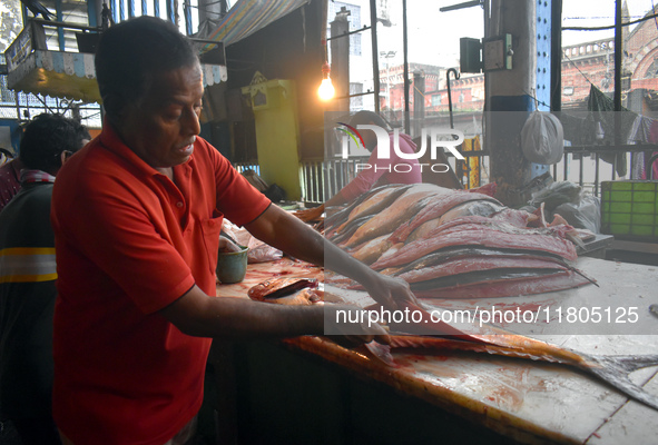 A vendor prepares fish inside a wholesale market in Kolkata, India, on November 24, 2024. 