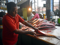 A vendor prepares fish inside a wholesale market in Kolkata, India, on November 24, 2024. (