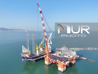 The offshore lifting platform "Boqiang 3060" lifts equipment for the offshore energy island project in the sea area of Yantai High-tech Zone...