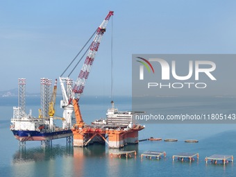 The offshore lifting platform "Boqiang 3060" lifts equipment for the offshore energy island project in the sea area of Yantai High-tech Zone...