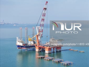 The offshore lifting platform "Boqiang 3060" lifts equipment for the offshore energy island project in the sea area of Yantai High-tech Zone...