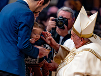 Pope Francis greets a newborn during the Holy Mass on World Youth Day on November 24, 2024. (