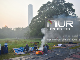 People burn fires, causing smoke on a smoggy morning in Kolkata, India, on November 24, 2024. (