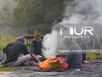 People burn fires, causing smoke on a smoggy morning in Kolkata, India, on November 24, 2024. (