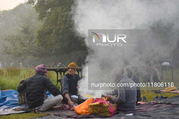 People burn fires, causing smoke on a smoggy morning in Kolkata, India, on November 24, 2024. 