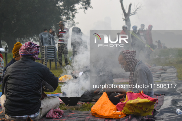 People burn fires, causing smoke on a smoggy morning in Kolkata, India, on November 24, 2024. 