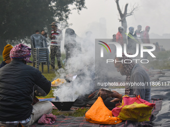 People burn fires, causing smoke on a smoggy morning in Kolkata, India, on November 24, 2024. (