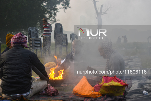 People burn fires, causing smoke on a smoggy morning in Kolkata, India, on November 24, 2024. 