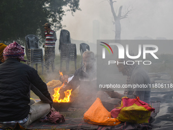 People burn fires, causing smoke on a smoggy morning in Kolkata, India, on November 24, 2024. (