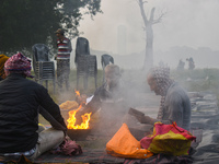 People burn fires, causing smoke on a smoggy morning in Kolkata, India, on November 24, 2024. (