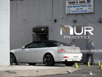 Evidence markers highlight where shell casings and other evidence are discovered by a white vehicle where a 35-year-old man is killed after...