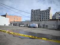 Evidence markers highlight where shell casings and other evidence are discovered by a white vehicle where a 35-year-old man is killed after...