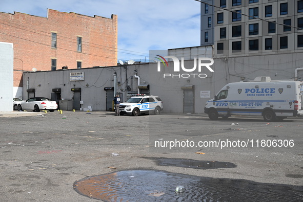 Evidence markers highlight where shell casings and other evidence are discovered by a white vehicle where a 35-year-old man is killed after...