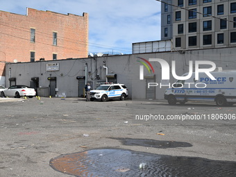 Evidence markers highlight where shell casings and other evidence are discovered by a white vehicle where a 35-year-old man is killed after...