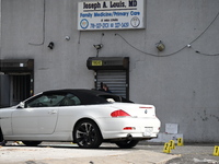 Evidence markers highlight where shell casings and other evidence are discovered by a white vehicle where a 35-year-old man is killed after...