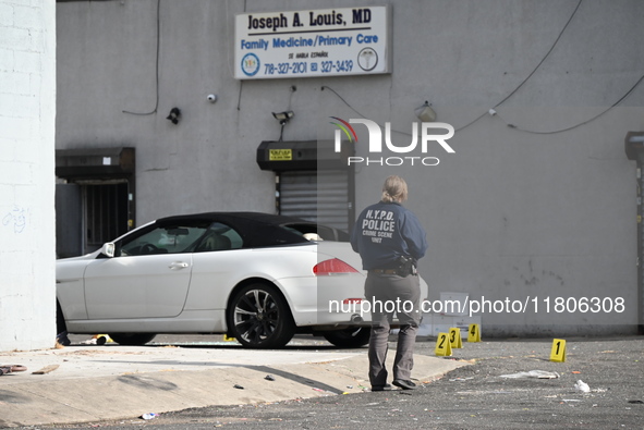 Evidence markers highlight where shell casings and other evidence are discovered by a white vehicle where a 35-year-old man is killed after...