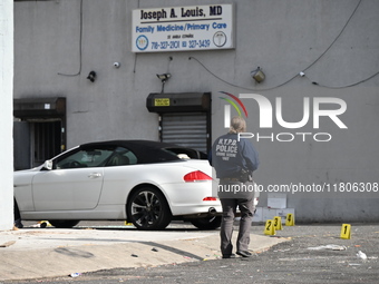 Evidence markers highlight where shell casings and other evidence are discovered by a white vehicle where a 35-year-old man is killed after...