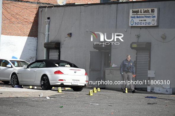 Evidence markers highlight where shell casings and other evidence are discovered by a white vehicle where a 35-year-old man is killed after...