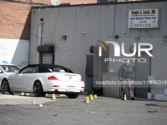 Evidence markers highlight where shell casings and other evidence are discovered by a white vehicle where a 35-year-old man is killed after...