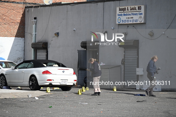 Evidence markers highlight where shell casings and other evidence are discovered by a white vehicle where a 35-year-old man is killed after...