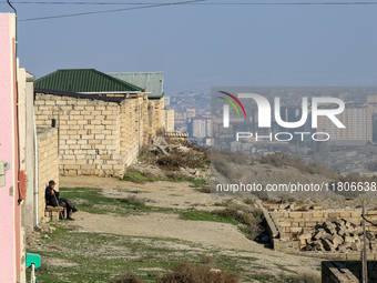 An elderly man sits on a bench in the suburbs of Baku, capital of Azerbaijan on November 24, 2024. (