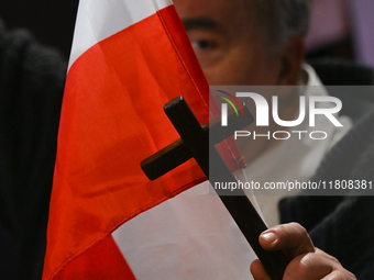 KRAKOW, POLAND - NOVEMBER 24:
One of the party supporters holds a Polish flag and a cross at the event where Karol Nawrocki was nominated as...