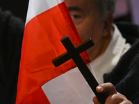 KRAKOW, POLAND - NOVEMBER 24:
One of the party supporters holds a Polish flag and a cross at the event where Karol Nawrocki was nominated as...