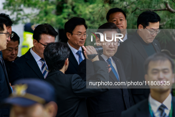 Lee Jae-myung (center), leader of the Democratic Party of Korea, waves to his supporters as he leaves the Seoul Central District Court in Se...