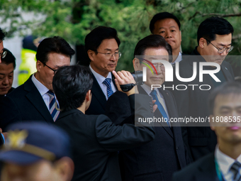 Lee Jae-myung (center), leader of the Democratic Party of Korea, waves to his supporters as he leaves the Seoul Central District Court in Se...