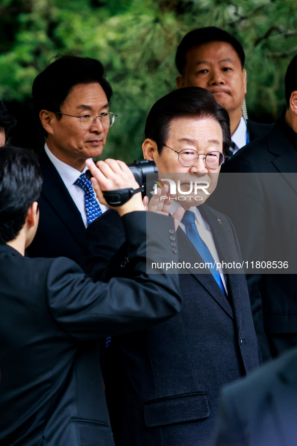 Lee Jae-myung (center), leader of the Democratic Party of Korea, waves to his supporters as he leaves the Seoul Central District Court in Se...