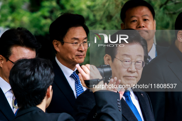 Lee Jae-myung (center), leader of the Democratic Party of Korea, waves to his supporters as he leaves the Seoul Central District Court in Se...