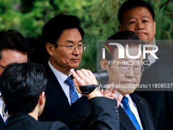 Lee Jae-myung (center), leader of the Democratic Party of Korea, waves to his supporters as he leaves the Seoul Central District Court in Se...