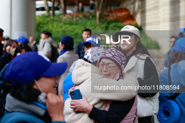 Supporters of Democratic Party leader Lee Jae-myung embrace each other in tears of joy outside the Seoul Central District Court in Seocho-gu...