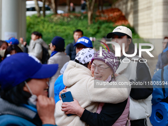 Supporters of Democratic Party leader Lee Jae-myung embrace each other in tears of joy outside the Seoul Central District Court in Seocho-gu...