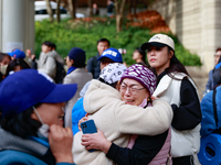 Supporters of Democratic Party leader Lee Jae-myung embrace each other in tears of joy outside the Seoul Central District Court in Seocho-gu...