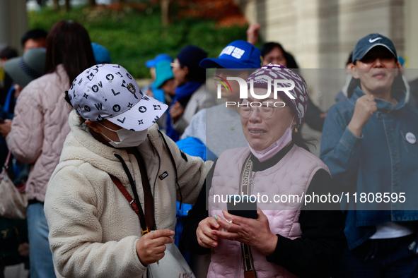 Supporters of Democratic Party leader Lee Jae-myung embrace each other in tears of joy outside the Seoul Central District Court in Seocho-gu...