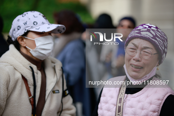 Supporters of Democratic Party leader Lee Jae-myung embrace each other in tears of joy outside the Seoul Central District Court in Seocho-gu...