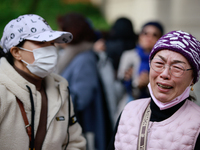 Supporters of Democratic Party leader Lee Jae-myung embrace each other in tears of joy outside the Seoul Central District Court in Seocho-gu...