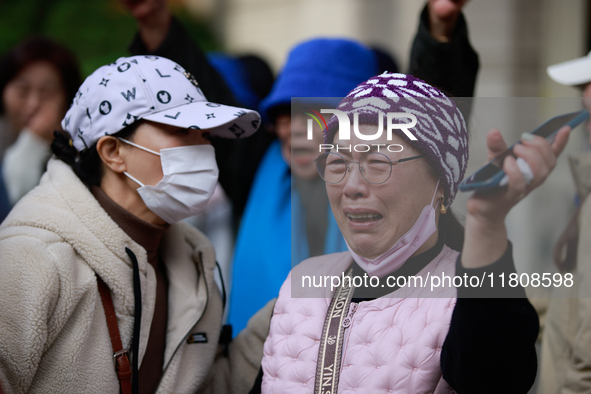 Supporters of Democratic Party leader Lee Jae-myung embrace each other in tears of joy outside the Seoul Central District Court in Seocho-gu...