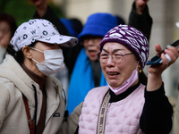 Supporters of Democratic Party leader Lee Jae-myung embrace each other in tears of joy outside the Seoul Central District Court in Seocho-gu...