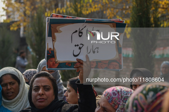 A female worker of the Jammu and Kashmir Pradesh Congress Committee (JKPCC) holds a placard during a protest demanding the restoration of st...