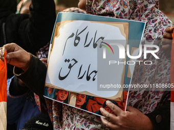 A female worker of the Jammu and Kashmir Pradesh Congress Committee (JKPCC) holds a placard during a protest demanding the restoration of st...