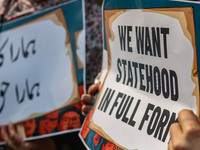 Female workers of the Jammu and Kashmir Pradesh Congress Committee (JKPCC) hold placards during a protest demanding the restoration of state...