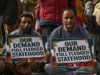 Members of the Jammu and Kashmir Pradesh Congress Committee (JKPCC) hold placards during a protest demanding the restoration of statehood an...