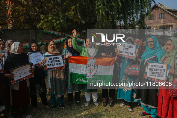 Female workers of the Jammu and Kashmir Pradesh Congress Committee (JKPCC) shout slogans and hold placards during a protest demanding the re...