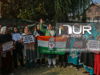 Female workers of the Jammu and Kashmir Pradesh Congress Committee (JKPCC) shout slogans and hold placards during a protest demanding the re...