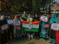 Female workers of the Jammu and Kashmir Pradesh Congress Committee (JKPCC) shout slogans and hold placards during a protest demanding the re...