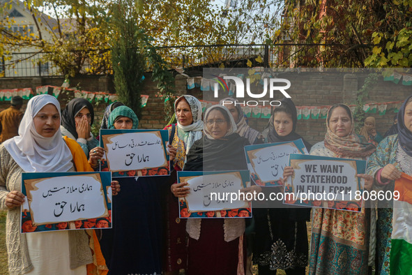 Female workers of the Jammu and Kashmir Pradesh Congress Committee (JKPCC) shout slogans and hold placards during a protest demanding the re...